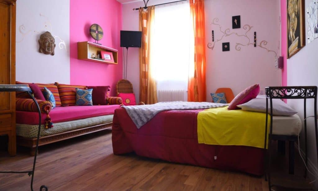 Home 2 a room with pink walls and a bed