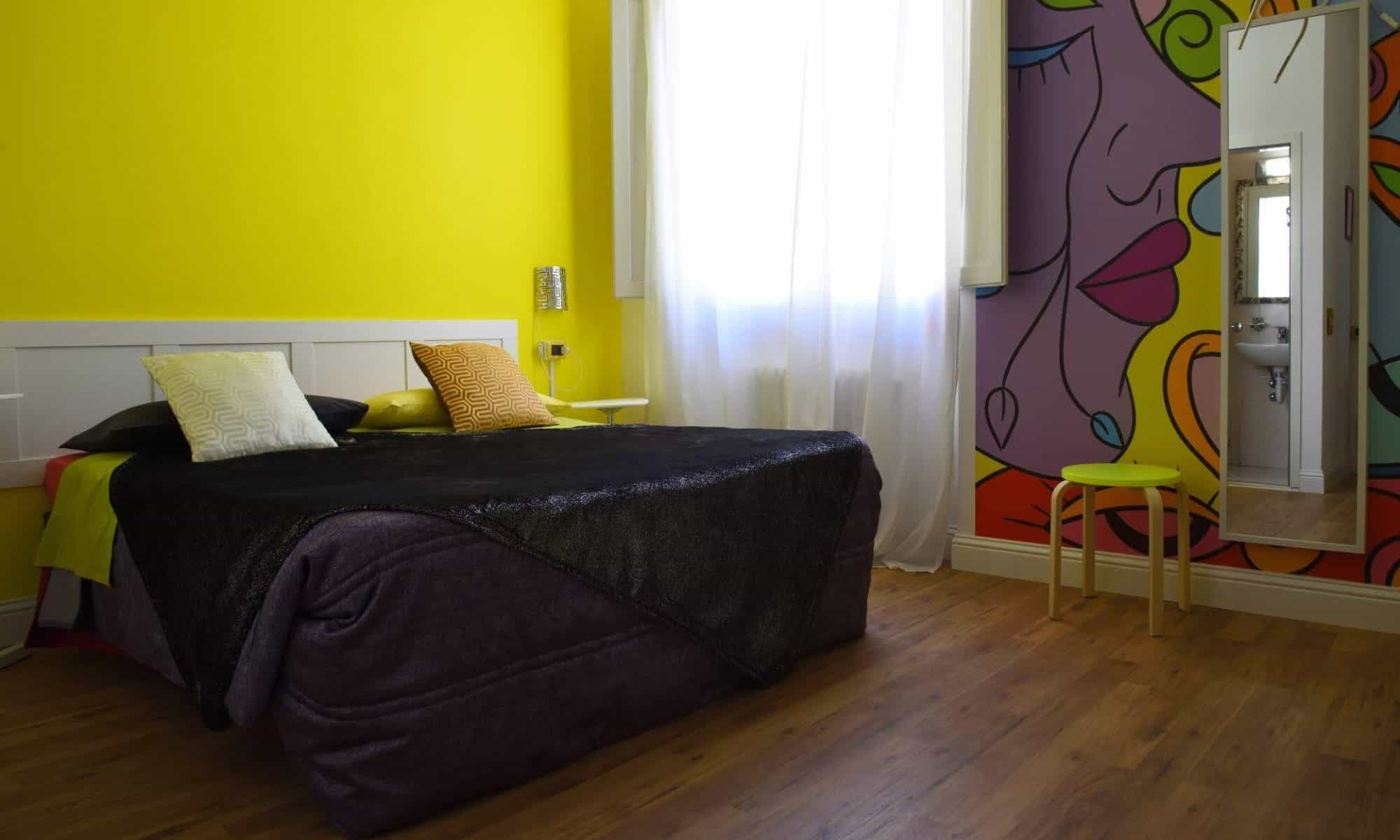 Home 1 a bed in a room with a yellow wall and a green chair